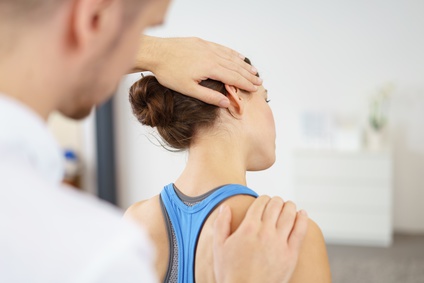 physiotherapeut behandelt eine patientin mit nackenschmerzen